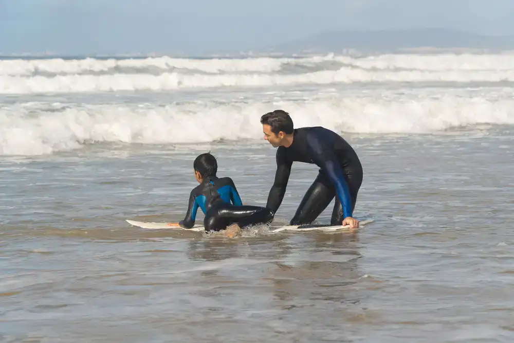 Instructor guiding a beginner into the cold water