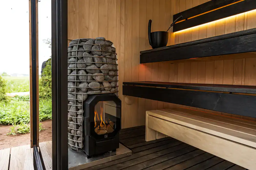 Members chatting inside a cozy, wood-fired sauna room